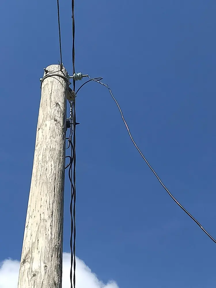 Poste de madera con la bajada de la acometida
