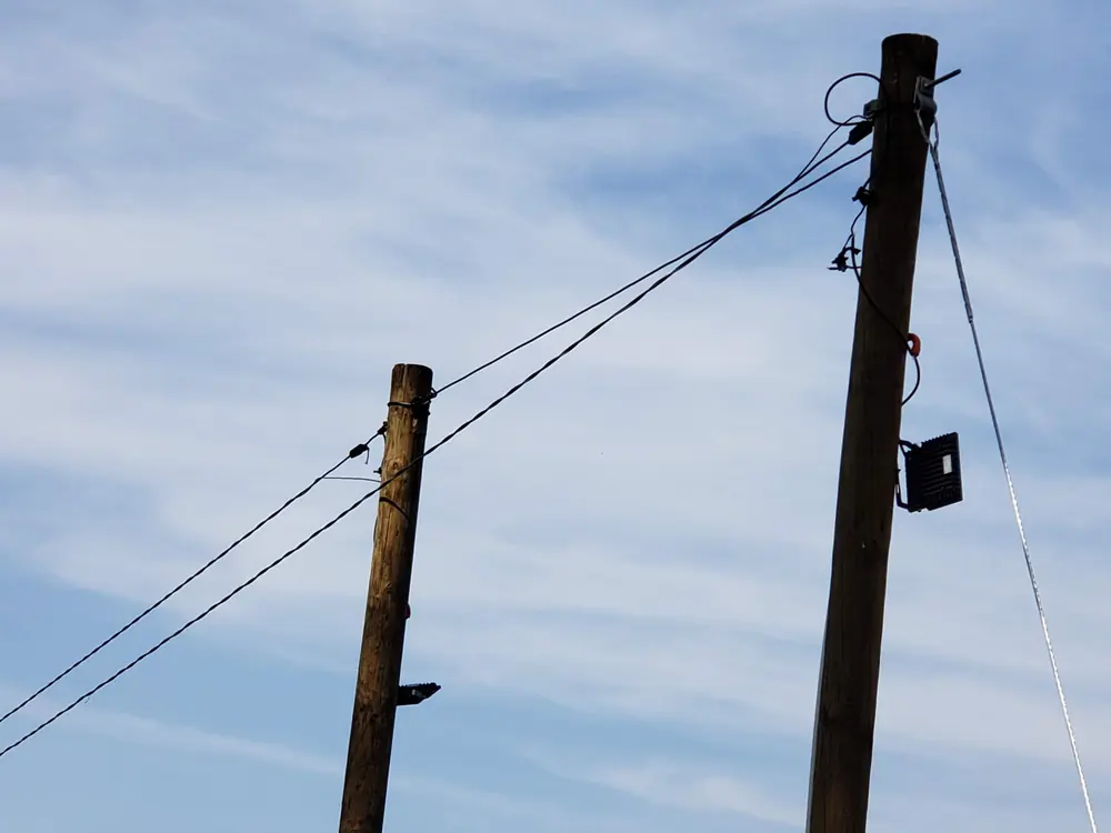 Dos postes con acometida aérea contra el cielo