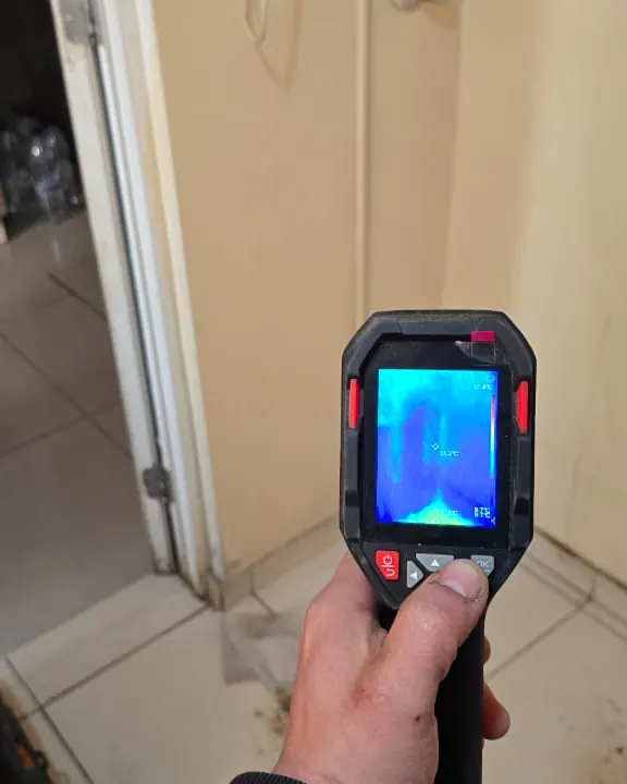 Pantalla de la cámara térmica con contraste azul frente a la puerta de una logia