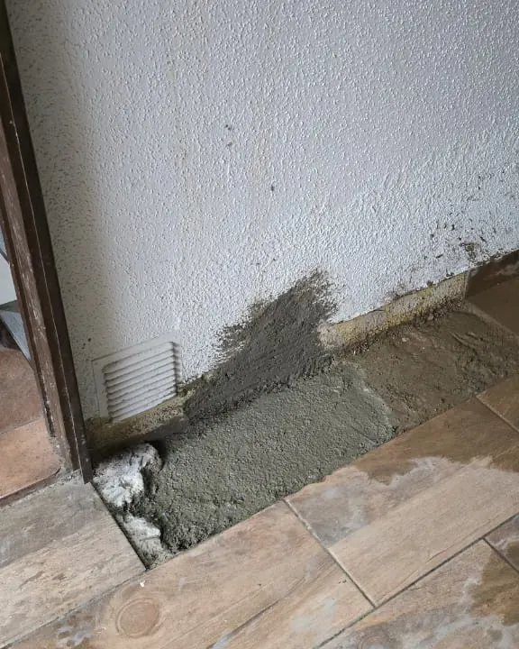 Franja de radier nuevo junto al muro de una cocina