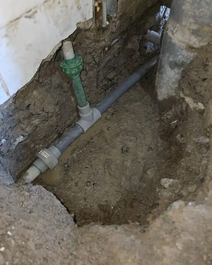 Tramo nuevo de cañería con fittings instalado en la excavación bajo el piso