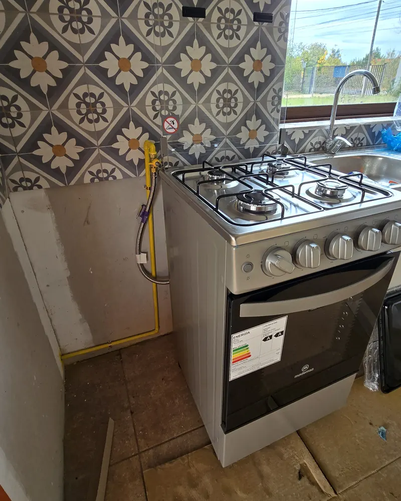 Cocina a gas instalada junto a un muro de azulejos