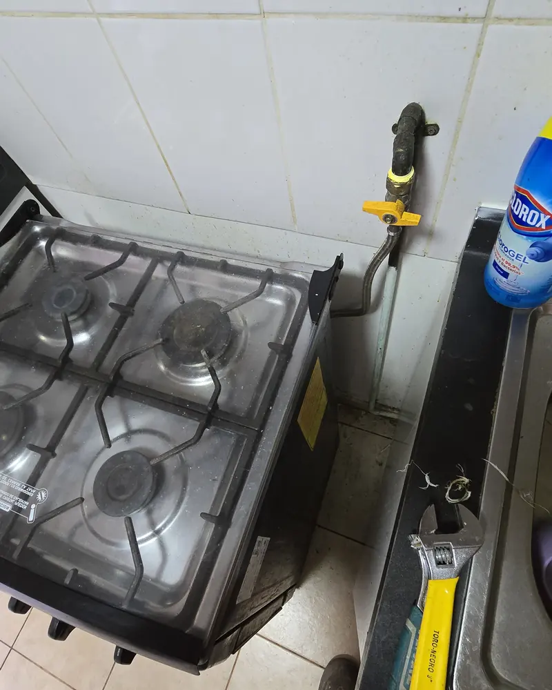 Cocina a gas junto a un muro con una llave de gas amarilla