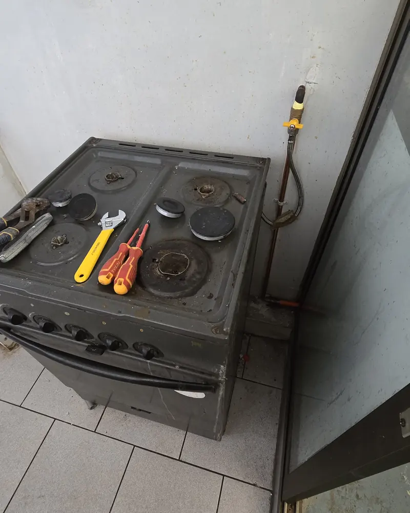 Cocina a gas en reparación con herramientas