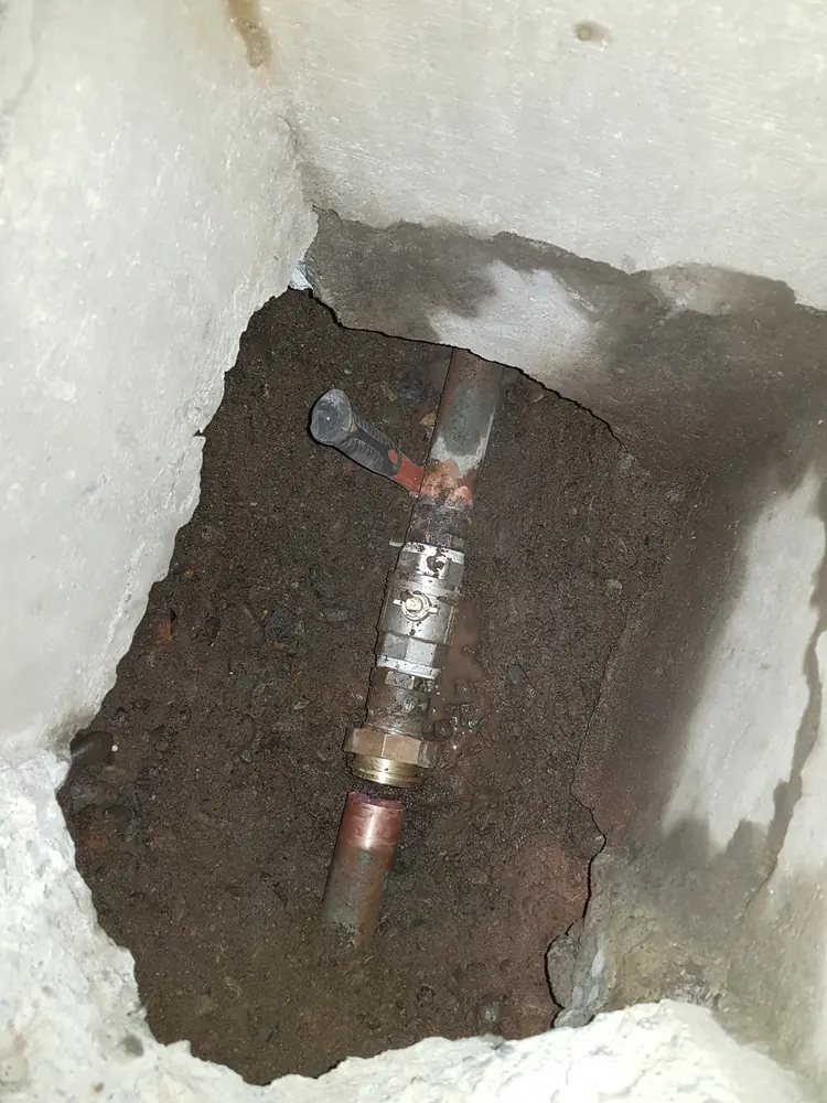 Cañería de cobre con una unión nueva bajo el piso abierto
