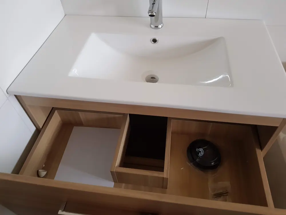 Vanitorio de madera con lavamanos blanco instalado