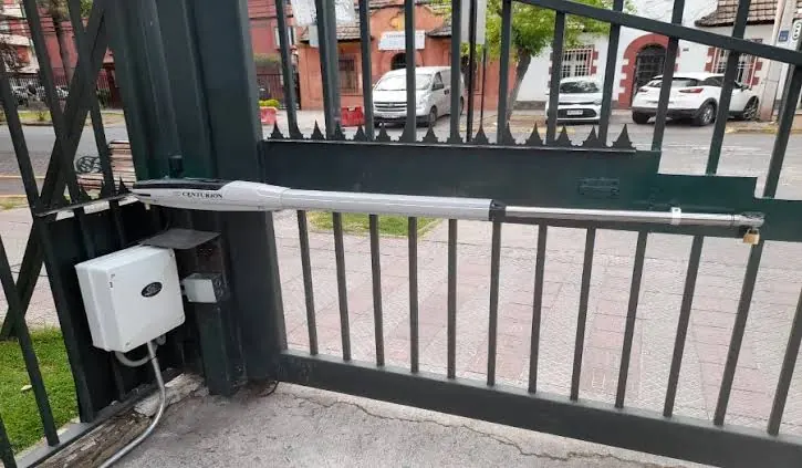 Brazo electromecánico instalado en una hoja de portón batiente