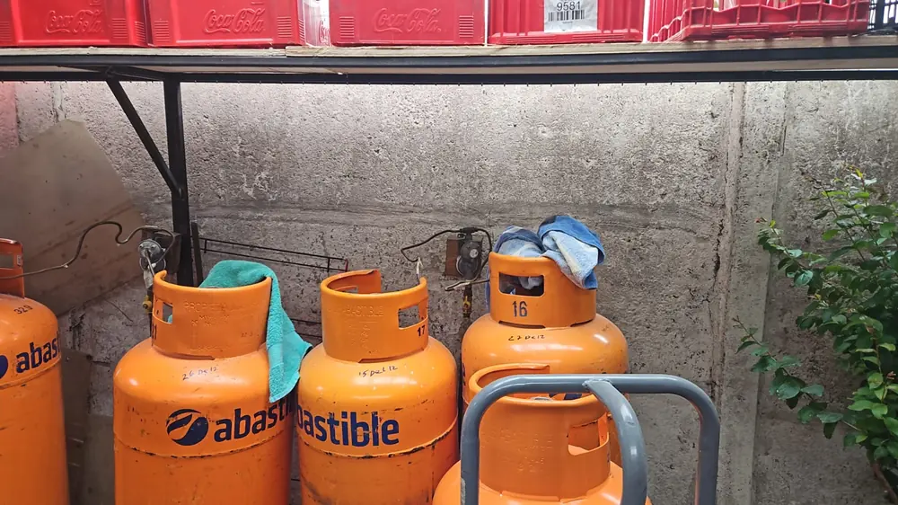 Fila de cilindros de gas de 45 kg conectados bajo un techo metálico