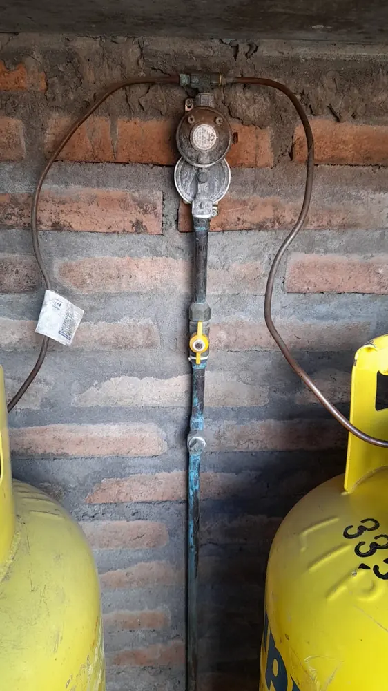 Reguladores y cilindros de gas en un muro de ladrillo