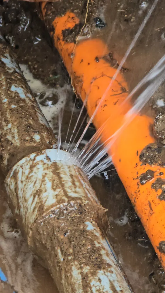 Chorro de agua en una cañería enterrada del patio